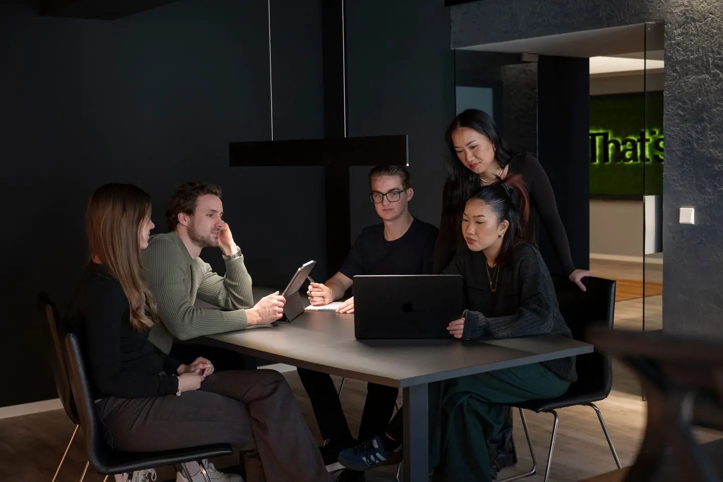 Fünf Mitarbeiter von That’s it. Marketing in einer Besprechung am Tisch