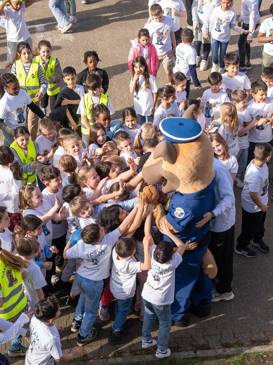 Kinder begrüßen Basko, das Maskottchen der Kinderschutzallianz