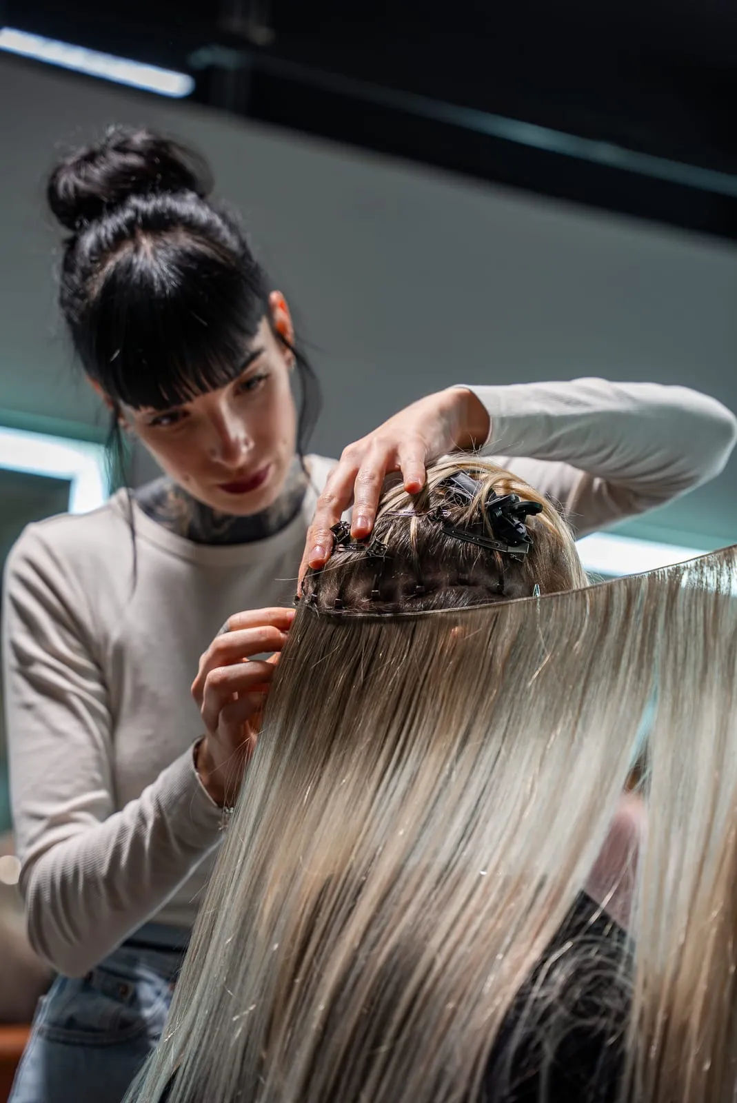 Friseurin bei der Arbeit an Haarverlängerungen