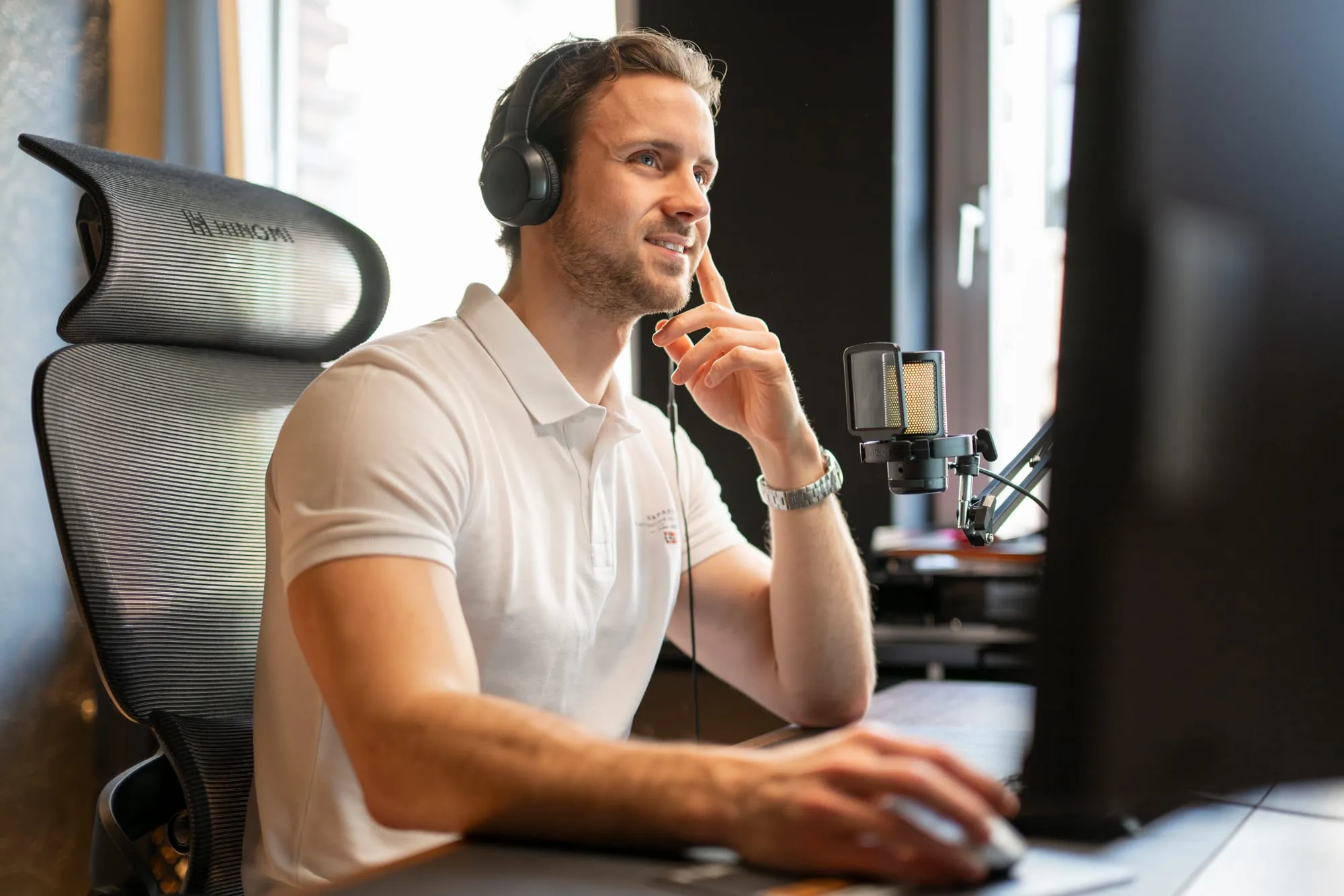Tim Barela am Arbeitsplatz mit Headset und Mikrofon